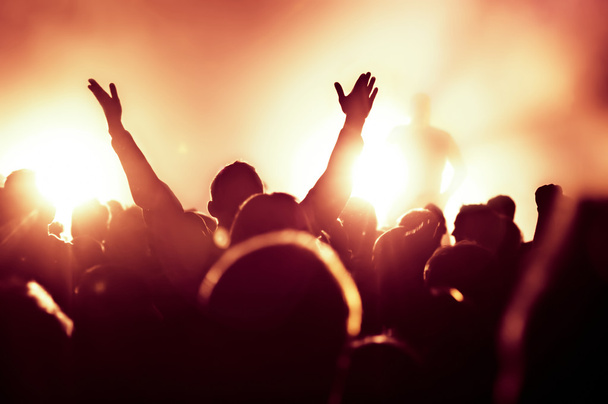 siluetas de la multitud de conciertos frente a luces de escenario brillantes - Foto, Imagen
