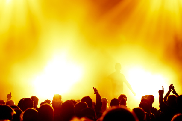 σιλουέτες των συναυλιών πλήθος μπροστά από φωτεινά φώτα σκηνής - Φωτογραφία, εικόνα