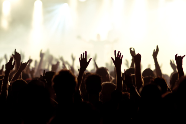 silhouetten van concertmenigte voor felle podiumlichten - Foto, afbeelding