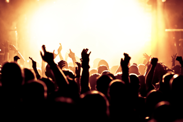 siluetas de la multitud de conciertos frente a luces de escenario brillantes - Foto, Imagen