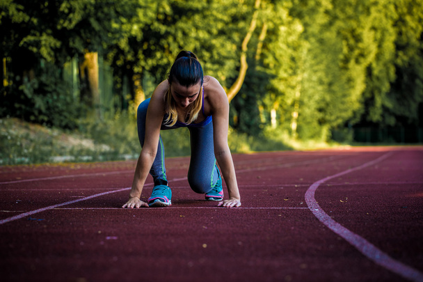 спортивная девушка на беговой дорожке готова к бегу, крупным планом
 - Фото, изображение