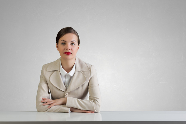 Businesswoman sitting at desk . Mixed media - Zdjęcie, obraz