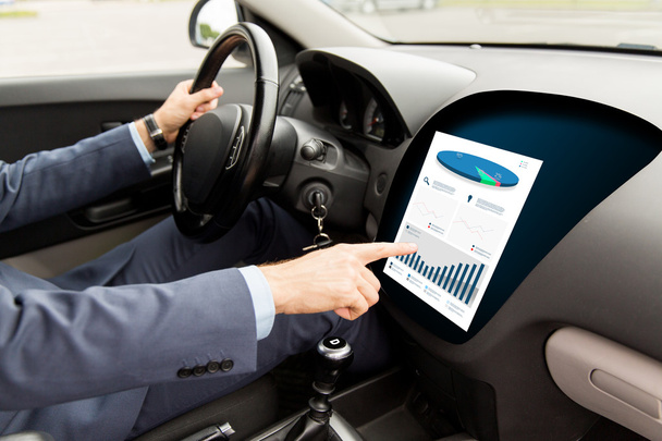 close up of man driving car with chart on screen - Foto, Imagen