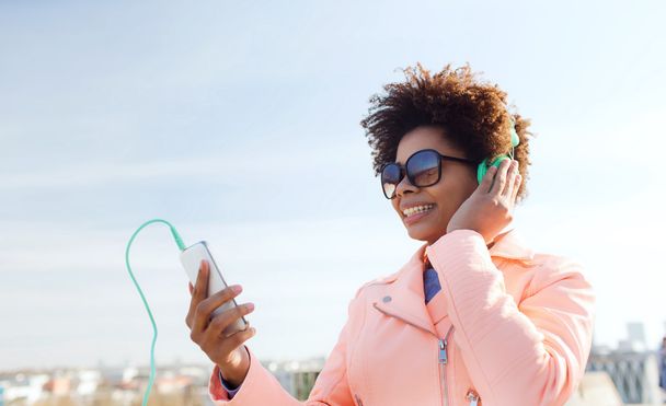 happy young woman with smartphone and headphones - Fotó, kép