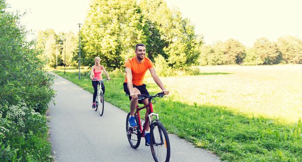 happy couple riding bicycle outdoors - Photo, Image