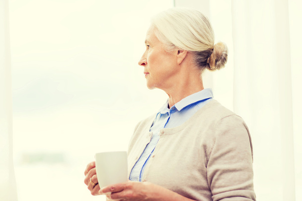 lonely senior woman with cup of tea or coffee - Foto, Bild