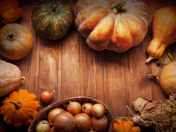 Осенние тыквы и другие фрукты и овощи на деревянном столе
 - Фото, изображение