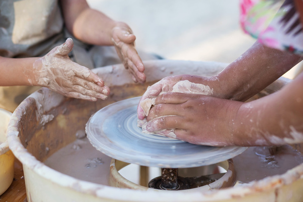 Hands of young potter, creating an earthen jar on the circle, cl - Photo, Image