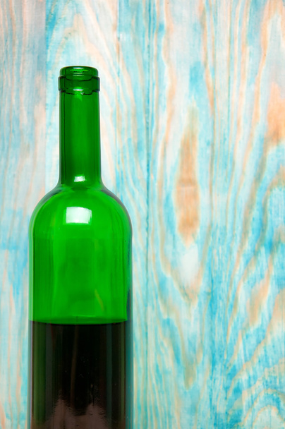 Botella de vino sobre fondo de madera
 - Foto, Imagen