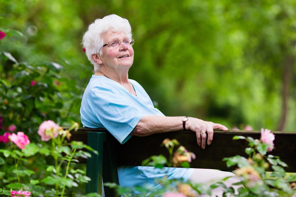 Senior senhora no jardim de rosas
 - Foto, Imagem