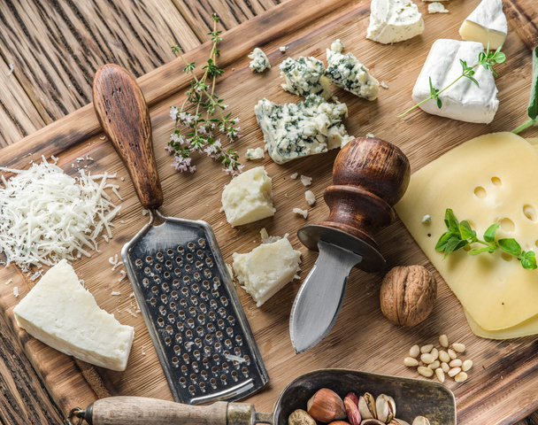Different types of cheeses with nuts and herbs. - Foto, Bild