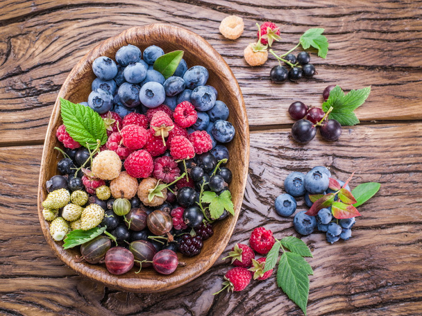 Ripe berries in the wooden bowl. - Foto, Imagen