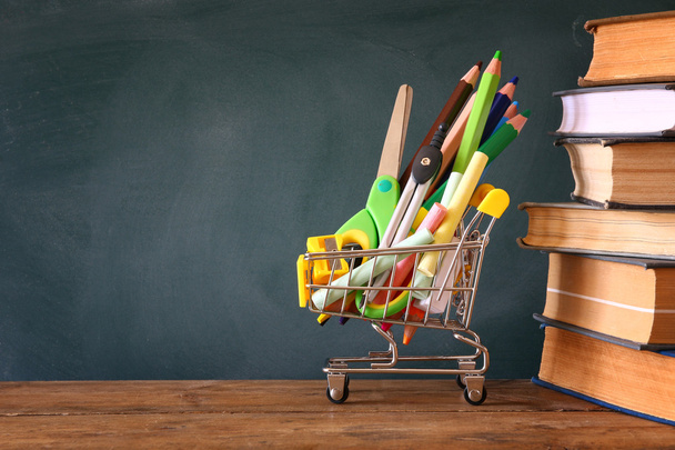 Shopping cart with school supply and books - Fotó, kép