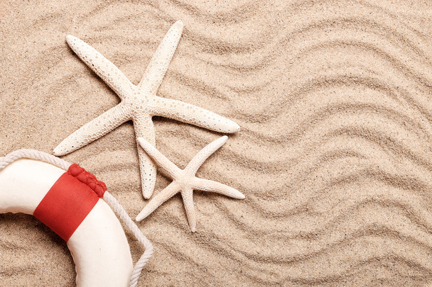 Summer concept, Idea for starfish and life ring on sand. - Valokuva, kuva