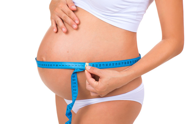 Pregnancy. Health of pregnant women. Measuring size tummy with meter tape - Foto, Imagem