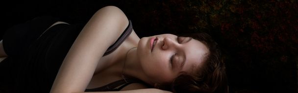 Woman lying on her side against dark background - Photo, image
