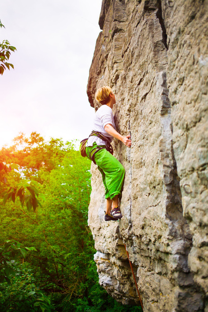 Het meisje klimt de rots. - Foto, afbeelding