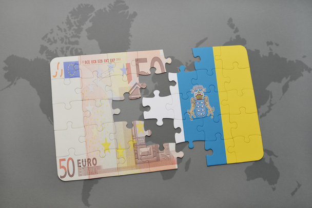 головоломка с национальным флагом канарейных островов и банкнотой евро на фоне карты мира
. - Фото, изображение