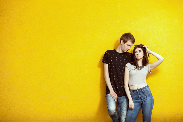Пара в моде позирует на желтой стене
 - Фото, изображение