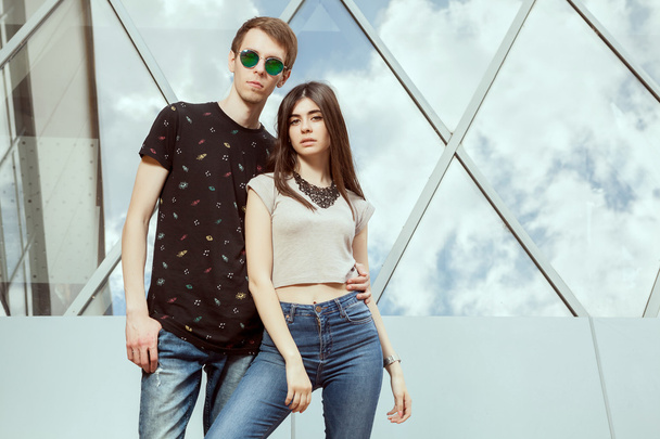 wunderschönes junges Paar posiert in Jeans vor dem Büro mit Brille  - Foto, Bild