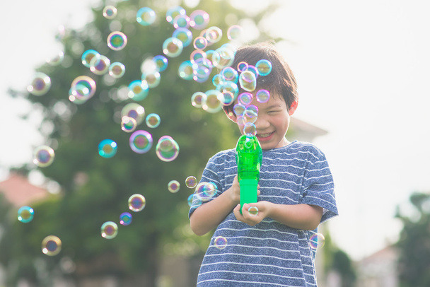 Asiático niño tiro burbujas de burbuja pistola
  - Foto, imagen