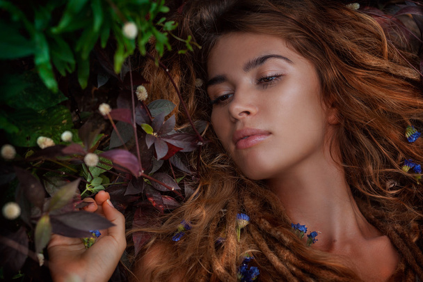 beautiful girl lying on the grass with flowers - Foto, imagen