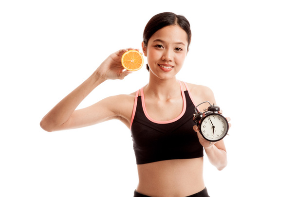 Beautiful Asian healthy girl with orange and clock - Фото, зображення