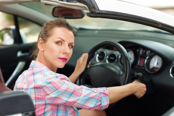 Woman sitting in a convertible and is going to start the engine - Photo, Image