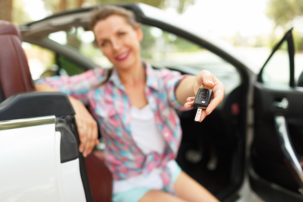 Mulher sentada em um carro conversível com as chaves na mão - conce
 - Foto, Imagem