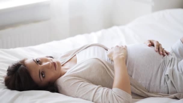happy pregnant woman touching her tummy at home 62 - Video, Çekim