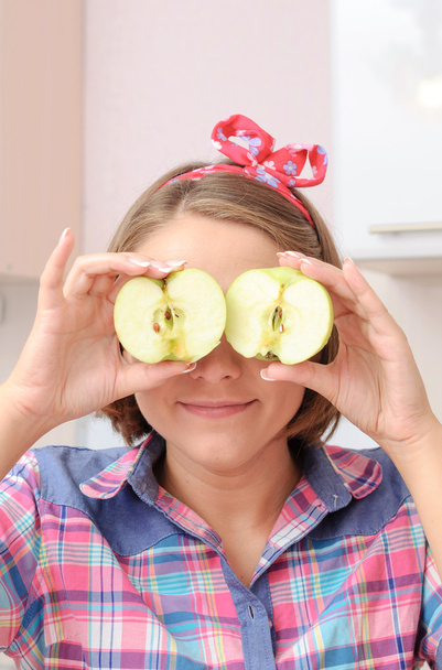 Happy young girl with two apples near her eyes - Fotoğraf, Görsel