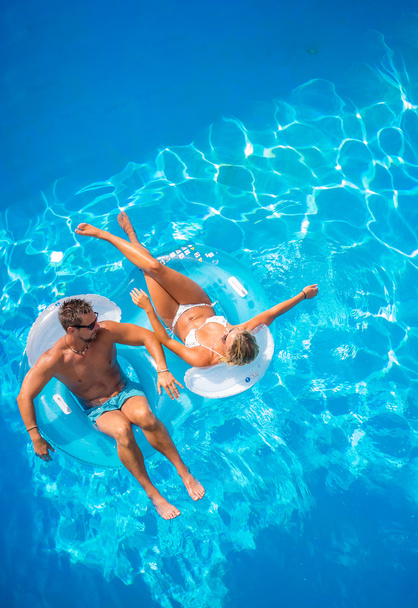 Boldog pár a lilos a medencében - Fotó, kép