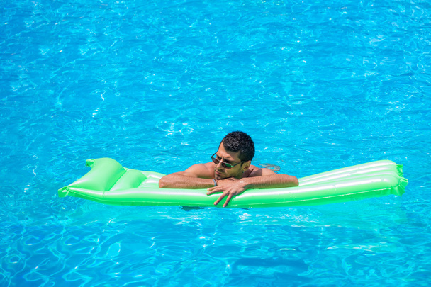 man relaxing on the air bed in the swimming pool. - Foto, Imagen