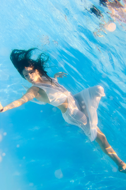 Woman in a white dress underwater in swimming pool - Zdjęcie, obraz