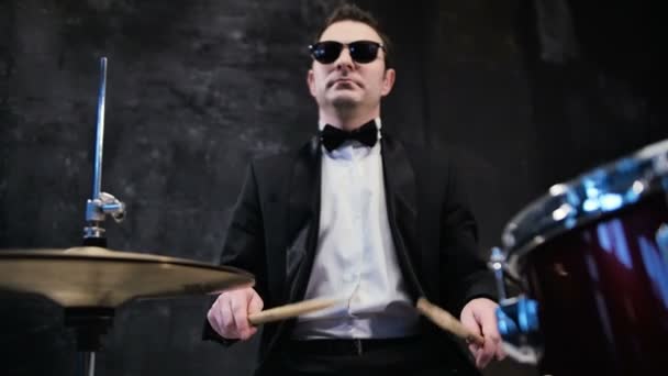 Man in black suit and sunglasses plays on drum. Rock cover band performing on stage with drummer - Záběry, video