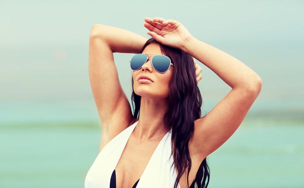 young woman with sunglasses on beach - Fotoğraf, Görsel