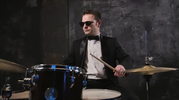 Man in black suit and sunglasses plays on drum. Rock cover band performing on stage with drummer - Footage, Video