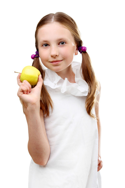 白い背景に分離された黄色リンゴを持って笑顔の少女の肖像画 - 写真・画像