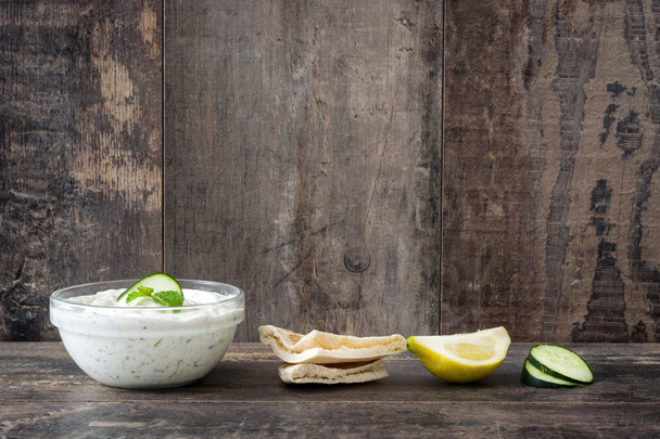 Tzatziki sauce and pita bread on rustic wooden background - Photo, Image