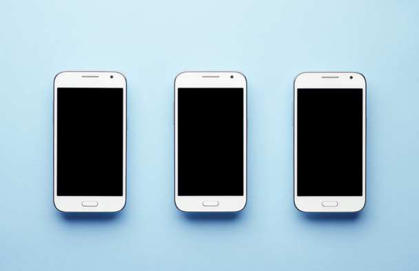 Três telefones inteligentes brancos
 - Foto, Imagem