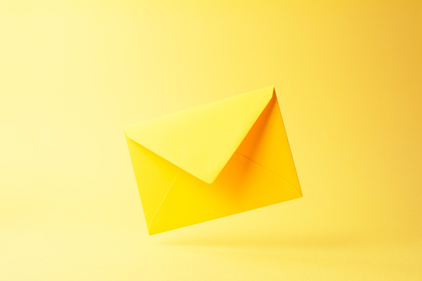 Gele envelop gedaald over geel - Foto, afbeelding