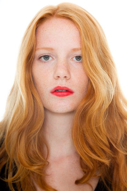 mooi meisje met lange rode haren en het dragen van lippenstift zwart shirt. mode studio opname geïsoleerd op witte achtergrond. - Foto, afbeelding