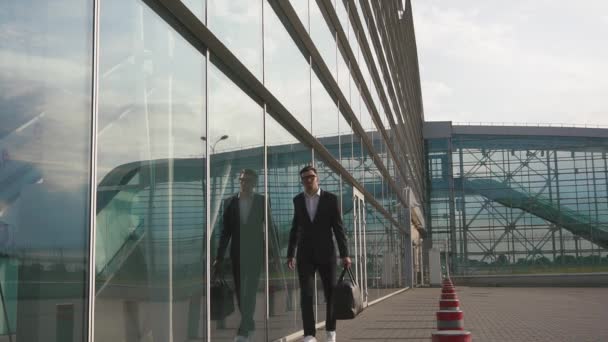 Elegant bearded businessman adjusts his jacket before work travel - Πλάνα, βίντεο