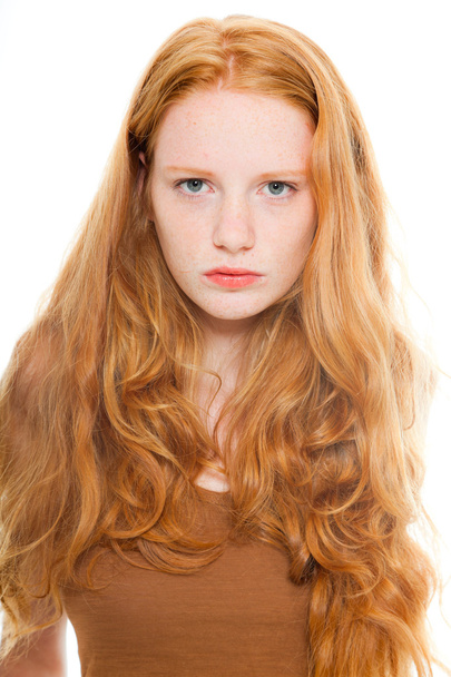 Красивая девушка с длинными рыжими волосами в коричневой рубашке. Студия моды сняла на белом фоне
. - Фото, изображение