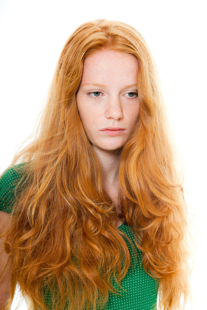 Красива дівчина з довгим рудим волоссям у зеленій сорочці. Природна краса. Студійний знімок моди ізольовано на білому тлі
. - Фото, зображення