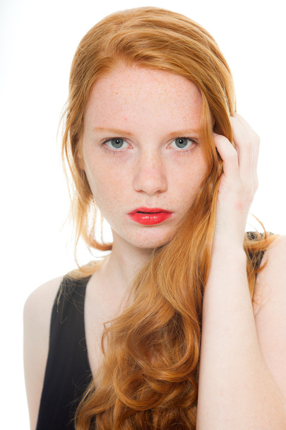 Jolie fille aux longs cheveux roux et rouge à lèvres portant une chemise noire. Studio de mode tourné isolé sur fond blanc
. - Photo, image