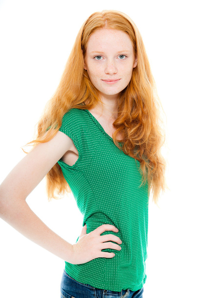 Улыбающаяся красивая девушка с длинными рыжими волосами в зеленой рубашке. Студия моды сняла на белом фоне
. - Фото, изображение