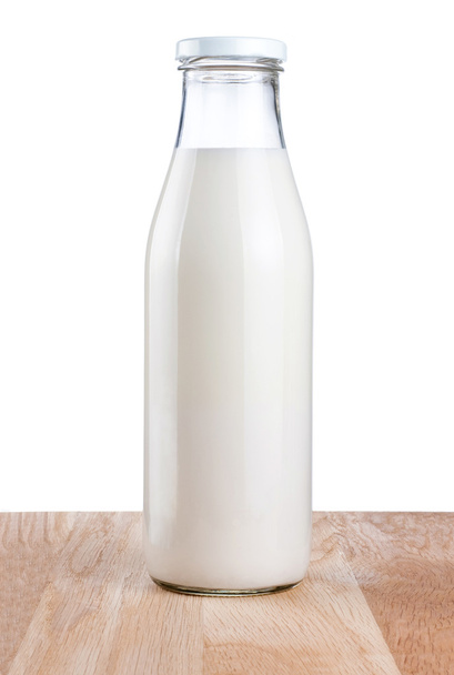 Bottle of fresh milk is wooden table Isolated on white backgroun - Фото, изображение