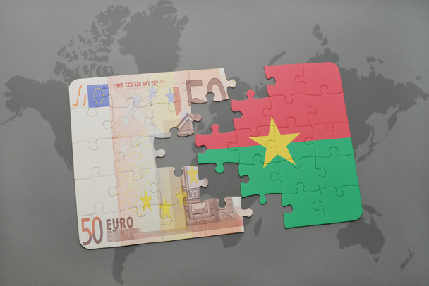 головоломка з національним прапором Буркіна-Фасо та банкнотою євро на фоні карти світу
. - Фото, зображення