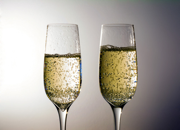 Two glass of champagne wine close up, bubbles, on a grey background - Fotó, kép